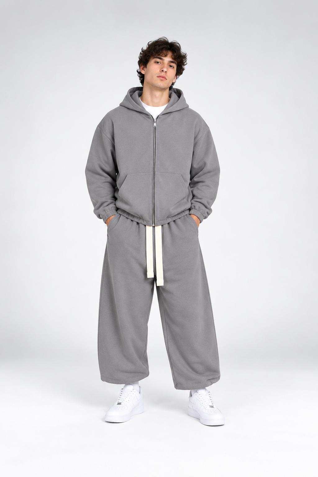 Completo TRACKSUIT WALF grigio in felpa, composto da felpa con cappuccio e zip e pantaloni ampi con coulisse bianca.